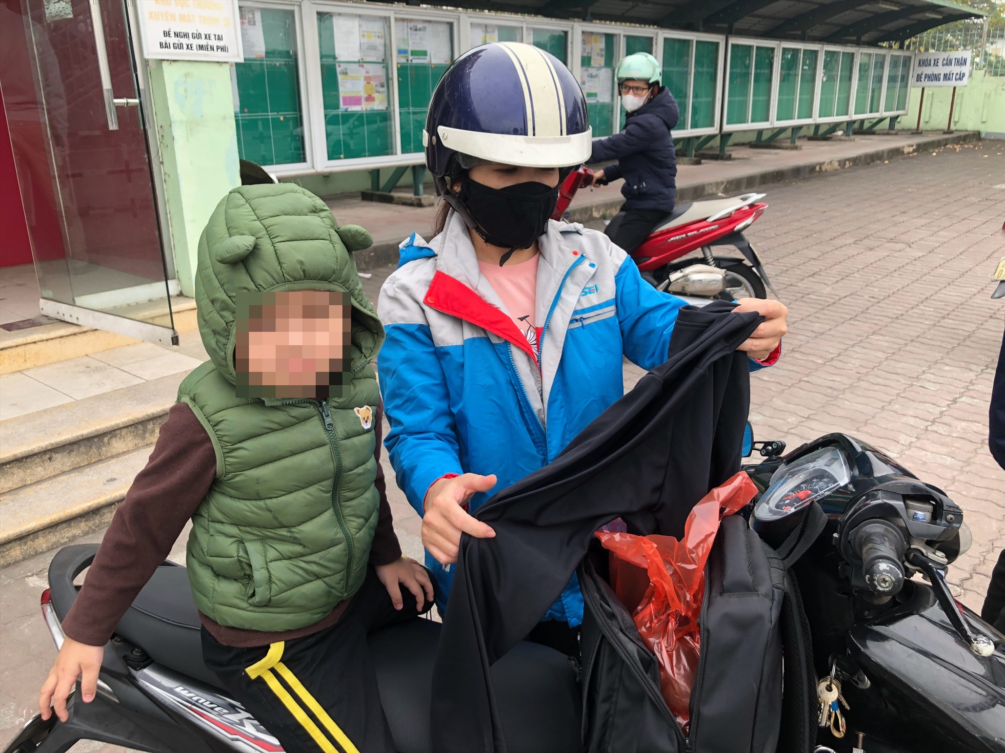 Chị Đàm Thị Hương khoe một vài bộ quần áo mới mà chị vừa mua cho các con để đón Tết. Nữ công nhân này không dám rút hết tiền, bởi còn để dành một khoản chi tiêu cho gia đình sau Tết. Ảnh: Bảo Hân