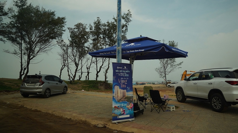 Cạnh dự án là một con đường có quy mô 4 làn xe chạy thẳng ra biển. Nơi đây tập trung hàng chục môi giới bắt khách đặt cọc giữ chỗ 50 triệu đồng dù dự án chỉ mới bãi đất trống.
